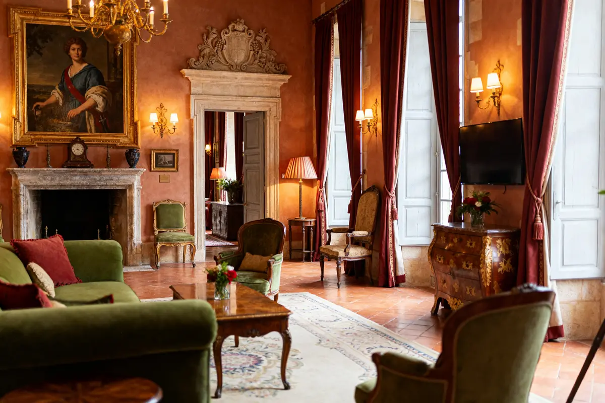 Salle élégante et raffinée du Château de Bagnols avec meubles anciens et cheminée ornée