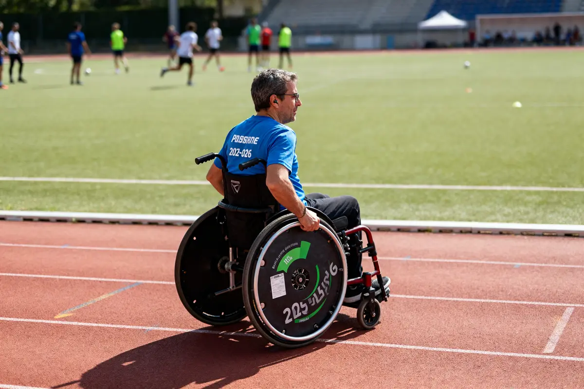 Homme en fauteuil roulant observant un match de football article diarioesportes.com terrain sportif