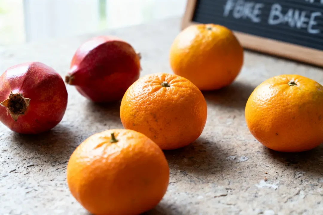 Oranges et grenades disposées sur le comptoir avec fruits exotiques orange en arrière-plan