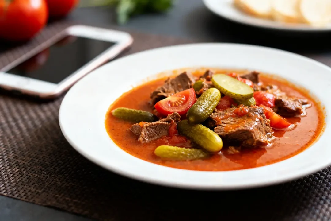 Plat de langue sauce piquante avec cornichons et tomates sur une table garnie